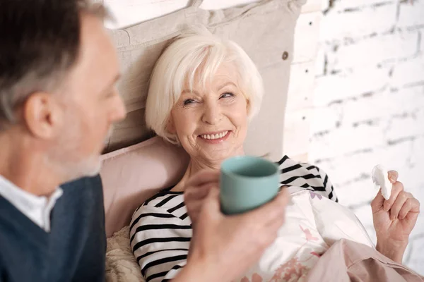 Крупный план пожилой женщины, пьющей чай от мужа — стоковое фото