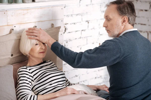 Hombre mayor midiendo la temperatura de su esposa — Foto de Stock