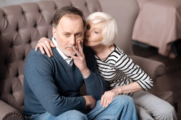 Senior lady kissing her sick husband — Stock Photo, Image