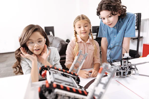 Потрясенные дети, наблюдающие за электронными роботами в школе — стоковое фото