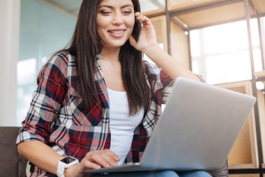 Dizüstü bilgisayar ekranına bakarak neşeli memnun kadın