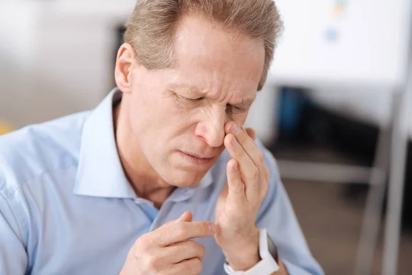 Hombre desaliñado mirando su nariz — Foto de Stock