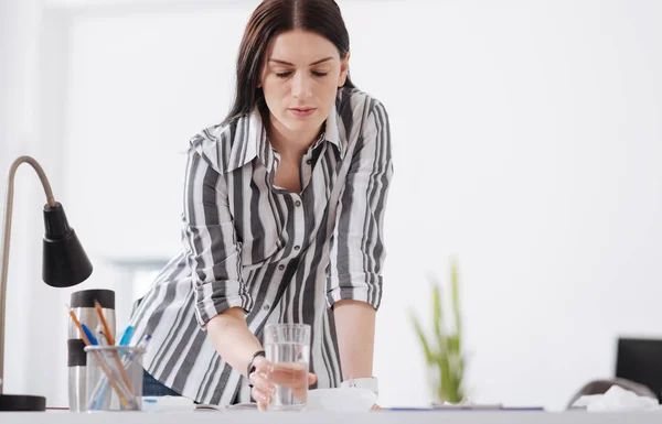 Chica concentrada tomando vidrio con agua dulce — Foto de Stock