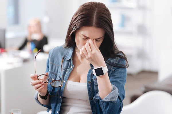 Yorgun kadın gözlüklerini alarak