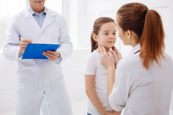 Ausgebildeter Kinderarzt unterzieht kleine Patientin einer Untersuchung — Stockfoto