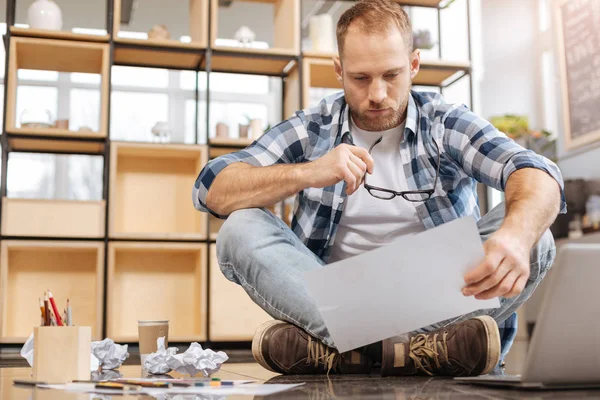 Nachdenklicher müder Mann sitzt im Schneidersitz auf dem Boden — Stockfoto