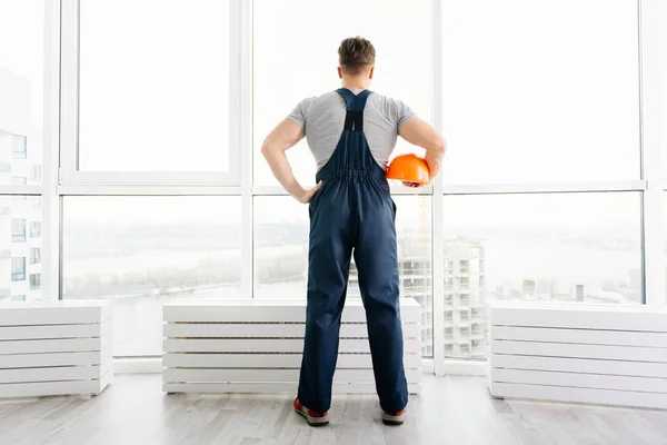 Rear view of construction engineer standing near big window — Stock Photo, Image