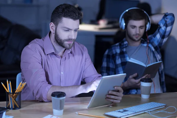 Programador guapo serio trabajando en una tableta — Foto de Stock