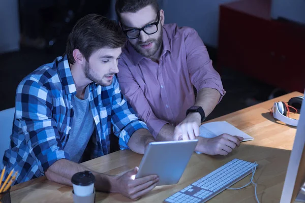 Inteligente hombre de TI bien parecido apuntando a la pantalla de la tableta — Foto de Stock