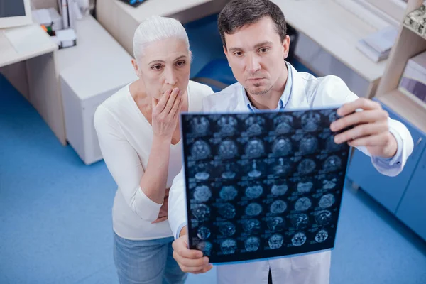 Σοβαρή σοκαρισμένος γυναίκα βλέπει τον εγκέφαλο ακτίνων X εικόνες — Φωτογραφία Αρχείου