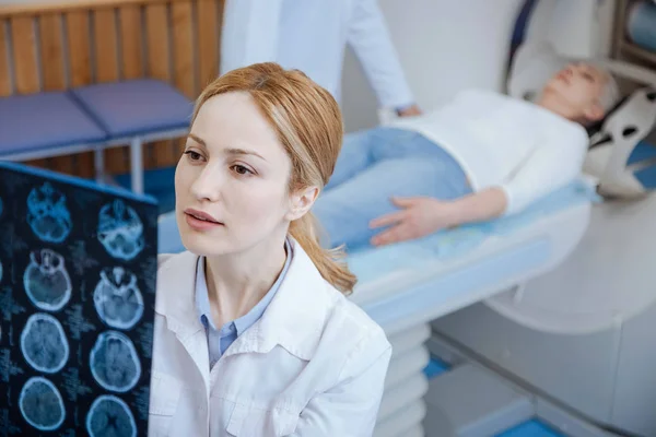 Oncologista feminina sério, examinando os resultados da tomografia — Fotografia de Stock