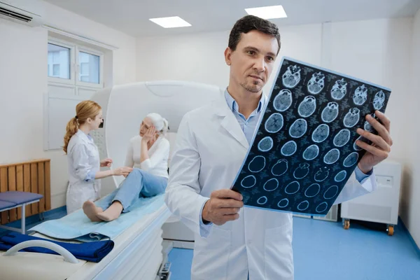Självsäker trevlig läkare som arbetar med Mri scan resultat — Stockfoto