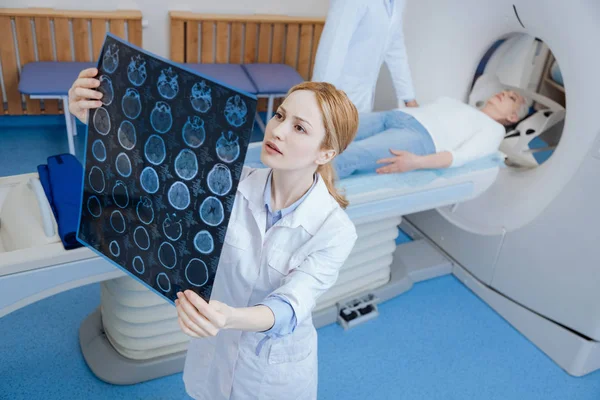 아름다운 여성 방사선 전문의 가 MRI 사진을 보고 있습니다. 스톡 사진