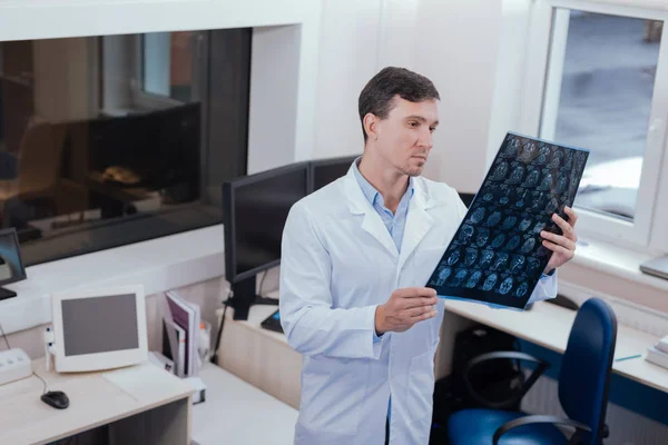 Seriöser männlicher Radiologe denkt über Diagnose nach — Stockfoto