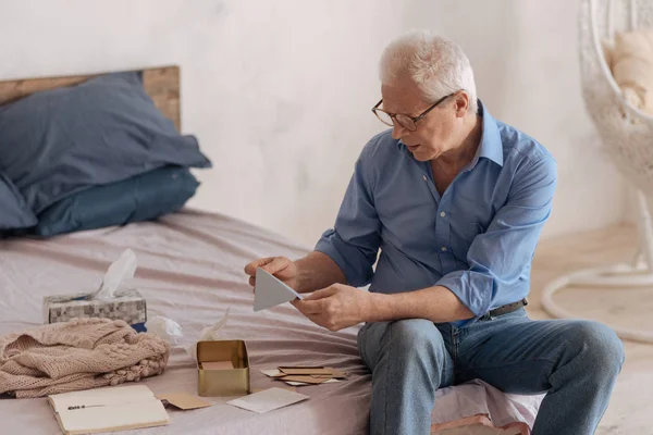 Несчастный пожилой человек с конвертом в руках — стоковое фото