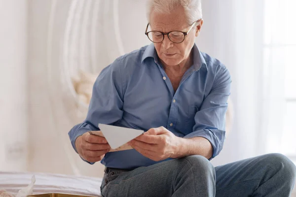 Launiger, fröhlicher Mann liest einen alten Brief — Stockfoto