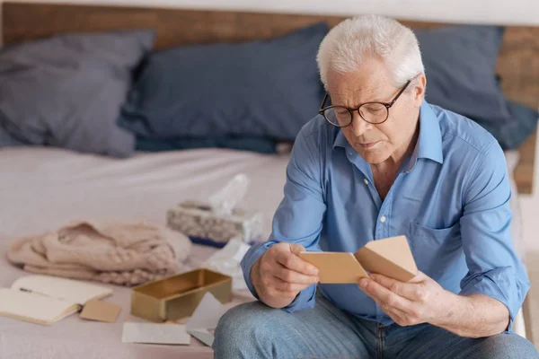 Snygg äldre mannen läser en anteckning — Stockfoto