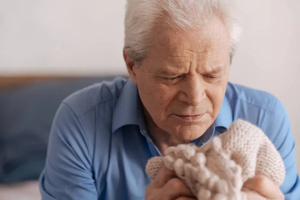 Humeurig oudere man kijken naar zijn wifes jasje — Stockfoto