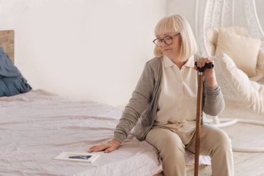 Gloomy depressed woman sitting on the bed clipart