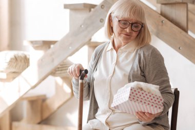 Bir hediye kutusu tutan güzel depresif kadın