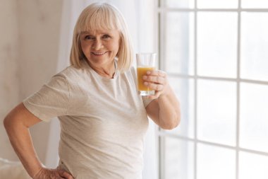 Bir bardak portakal suyu ile tutan neşeli mutlu kadın