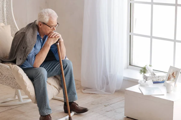 Deprimerade äldre man som sitter i fåtöljen — Stockfoto