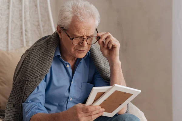 Triste pessimista uomo che fissa i suoi occhiali — Foto Stock