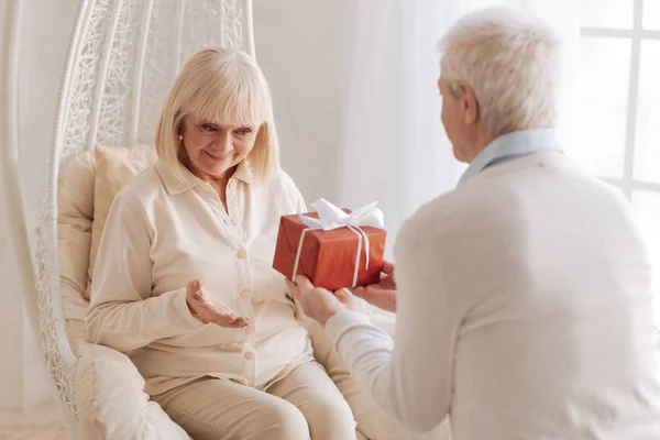 Bonito marido cariñoso dando a su esposa un regalo — Foto de Stock