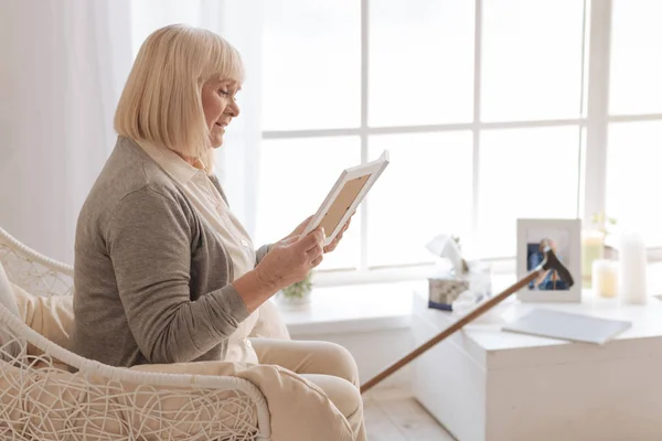 Olycklig glädjelös kvinna tittar på en bild — Stockfoto