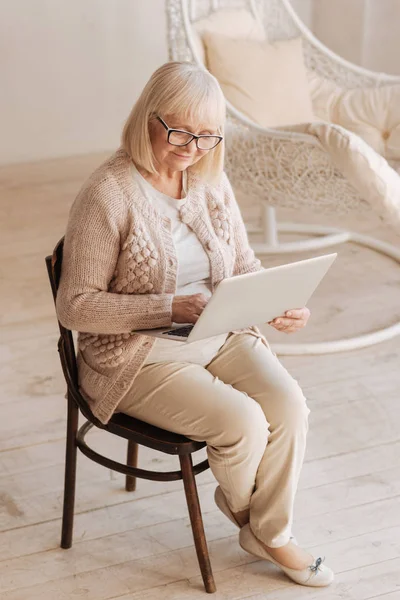 Pozitív idősebb nő, egy laptop tartó — Stock Fotó