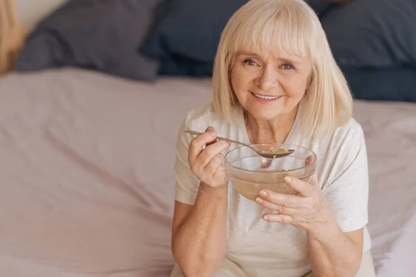 Mujer alegre positiva sosteniendo una cuchara — Foto de Stock