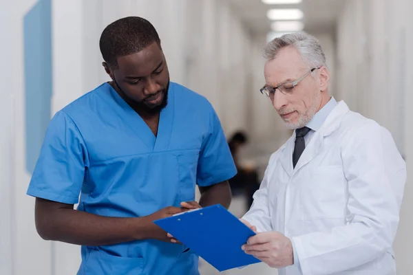 Medico anziano che insegna ai giovani tirocinanti afroamericani in ospedale — Foto Stock