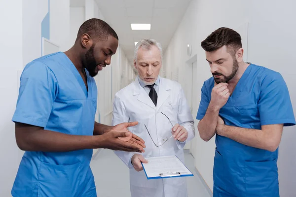 Begeisterte Praktikantin im Gespräch mit erfahrenen Kollegen am Arbeitsplatz — Stockfoto