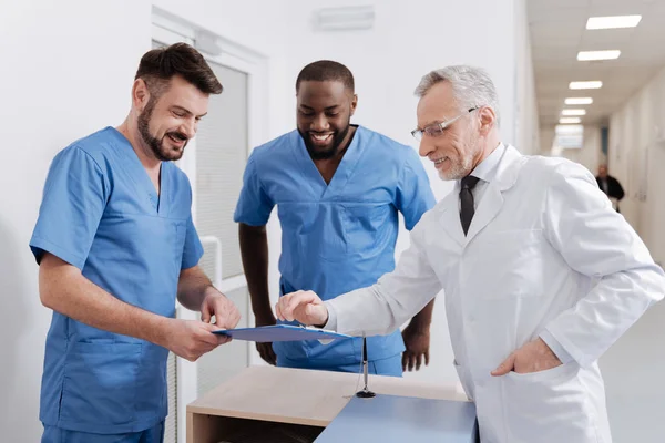 Позитивний досвідчений лікар перевіряє якість роботи в лікарні — стокове фото