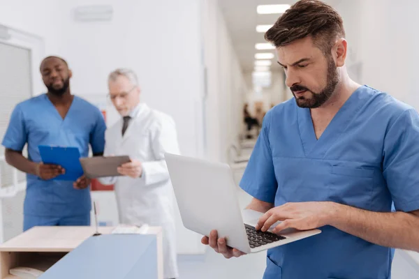 Medico barbuto che utilizza le moderne tecnologie in clinica — Foto Stock