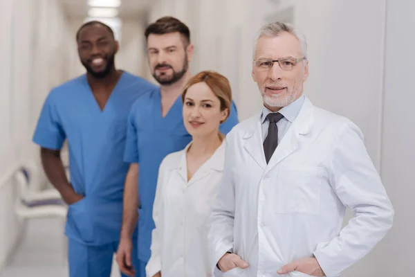 Betagter Arzt genießt Arbeitszeit in der Klinik — Stockfoto