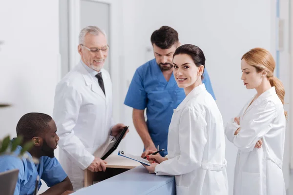 Pediatras alegres disfrutando de la conversación en el área de recepción de la clínica — Foto de Stock