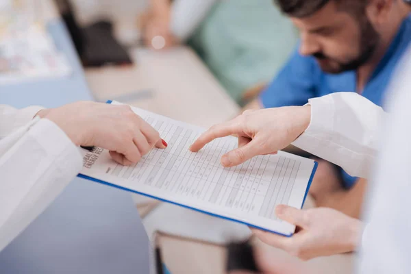 Aufmerksame Spezialisten erkunden die Informationen des Patienten in der Klinik — Stockfoto