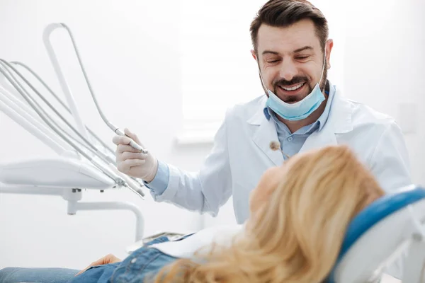 Schöner freundlicher Zahnarzt, der seinen Patienten beruhigt — Stockfoto