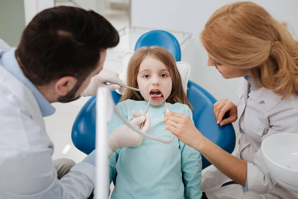 Equipe qualificada de dentistas que realizam um procedimento — Fotografia de Stock