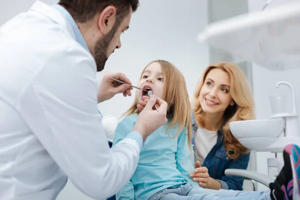 Uppmärksamma mamma saltning sitt barn till tandläkaren — Stockfoto