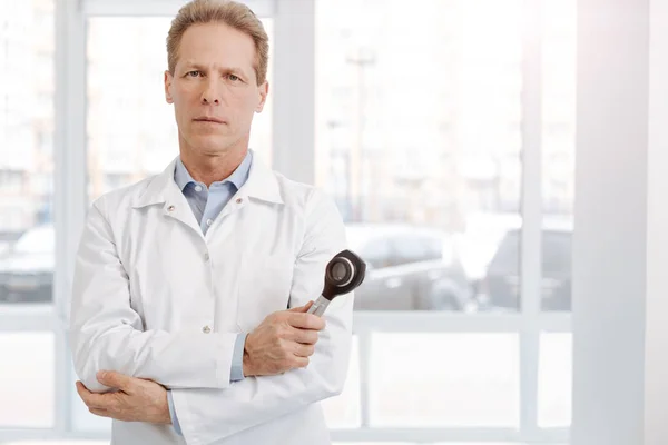 Confident aged dermatologist holding dermatoscope at work — Stock Photo, Image