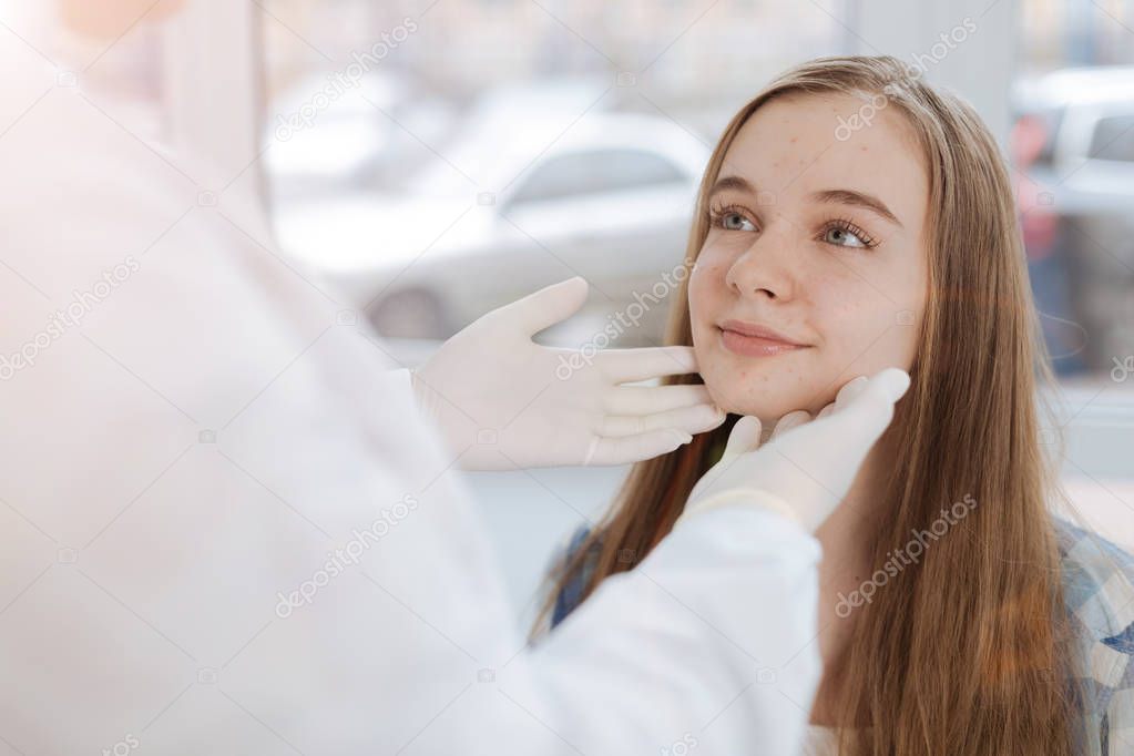Skilled dermatologist examining patient skin in the clinic