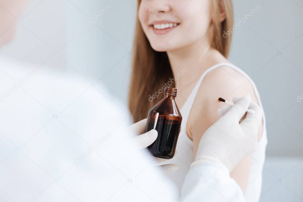 Young girl enjoying visit to the dermatologist in the hospital