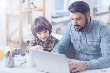 Baba ve oğul dizüstü bilgisayar kullanıyor.