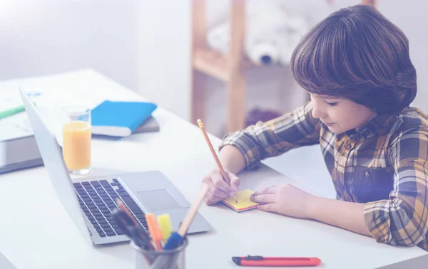 Boy writing down important information — Stock Photo, Image