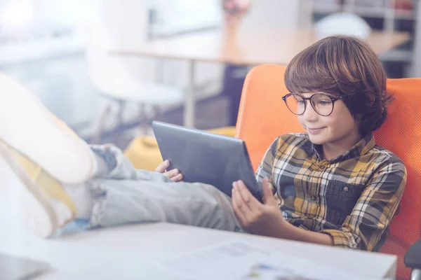 Junge nutzt digitales Tablet mit hochgezogenen Füßen — Stockfoto