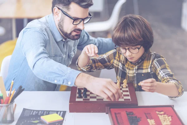Padre mostrando a su pequeño hijo cómo jugar al ajedrez — Foto de Stock
