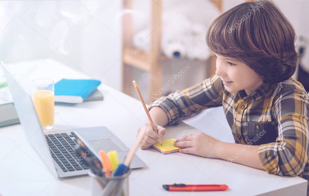 Beautiful little boy writing down notes