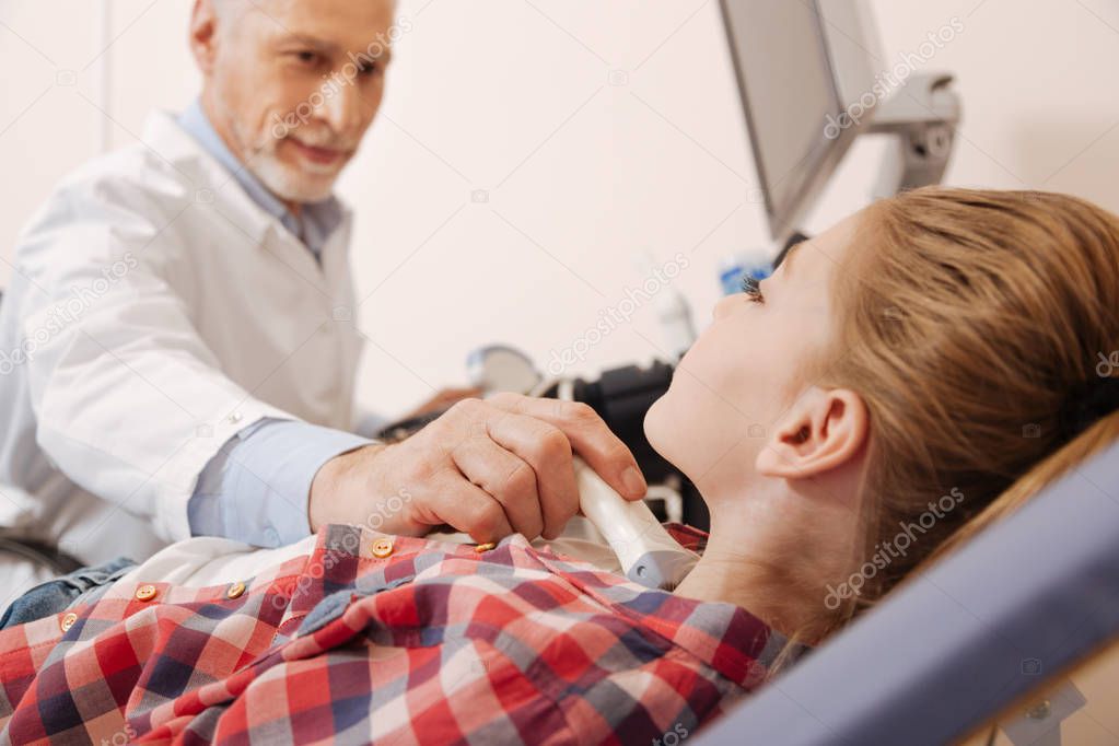 Elderly physician making ultrasound scanning 